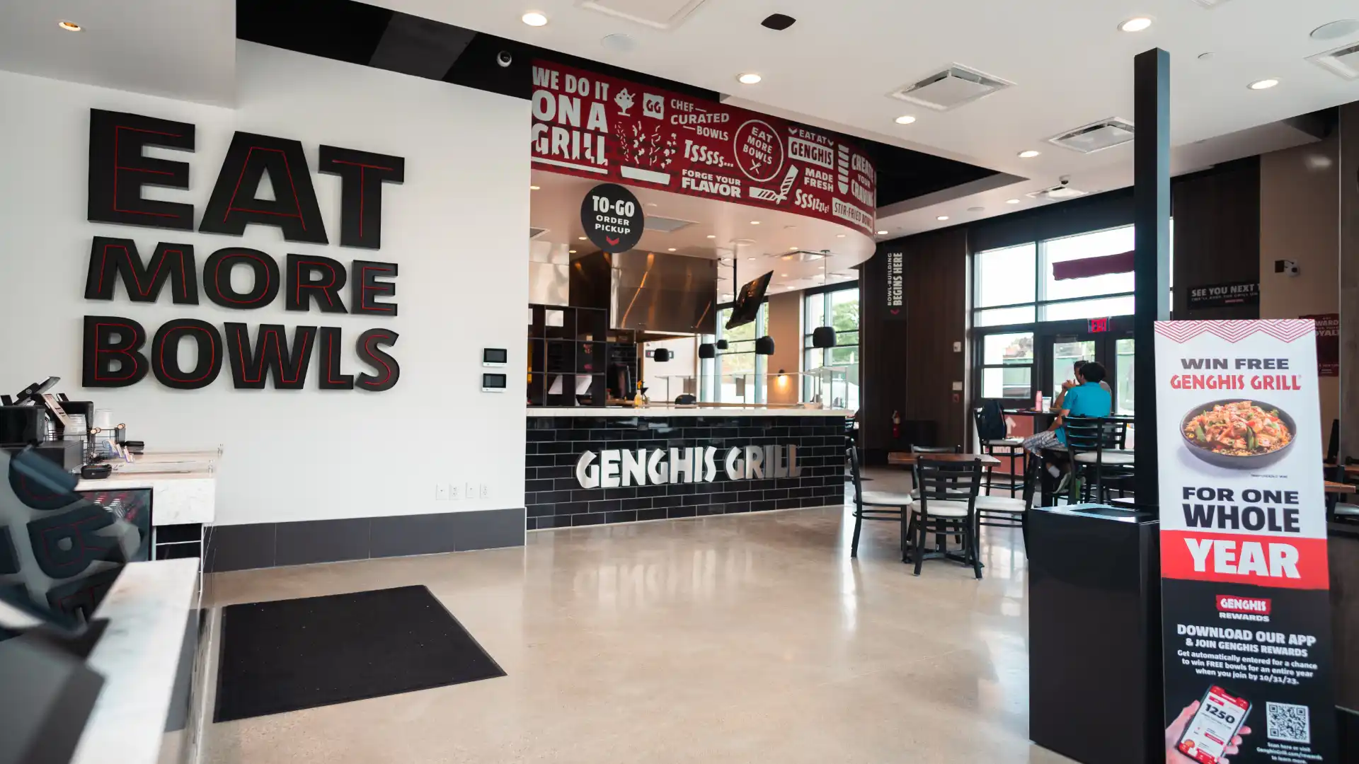 Guest building a custom bowl at Genghis Grill.